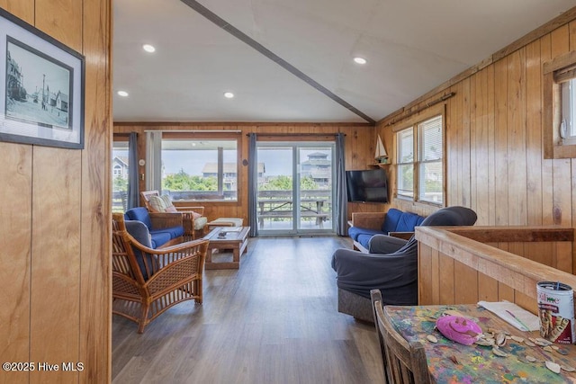 living room featuring vaulted ceiling, dark wood-type flooring, and wood walls