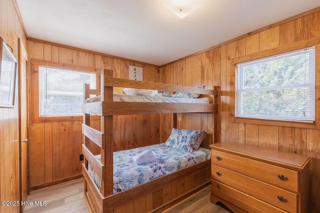 bedroom with wooden walls and light wood-type flooring