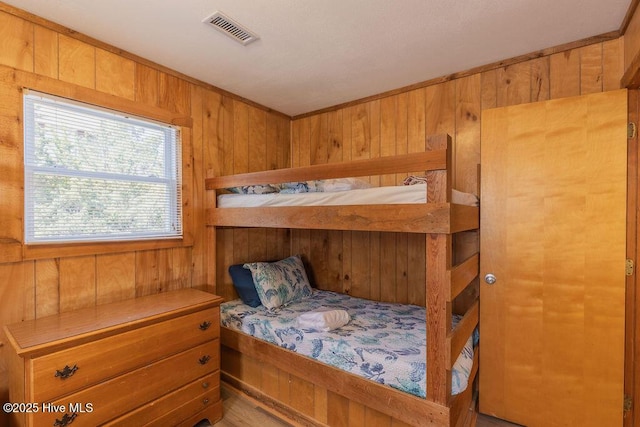 bedroom featuring wooden walls