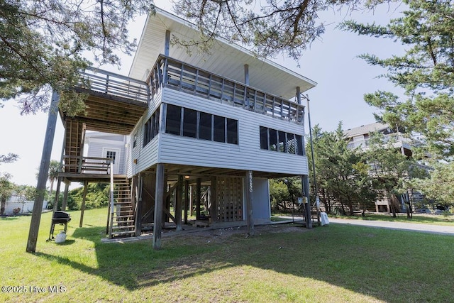 back of property featuring a sunroom and a yard