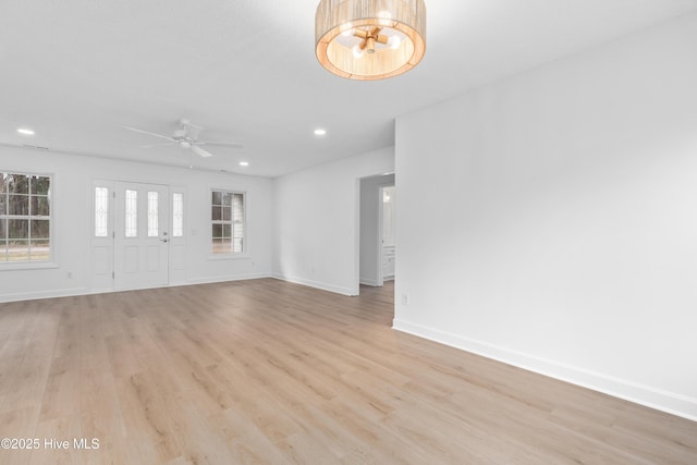 unfurnished living room featuring ceiling fan, light hardwood / wood-style floors, and a wealth of natural light