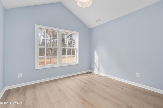 unfurnished room with light wood-type flooring and vaulted ceiling