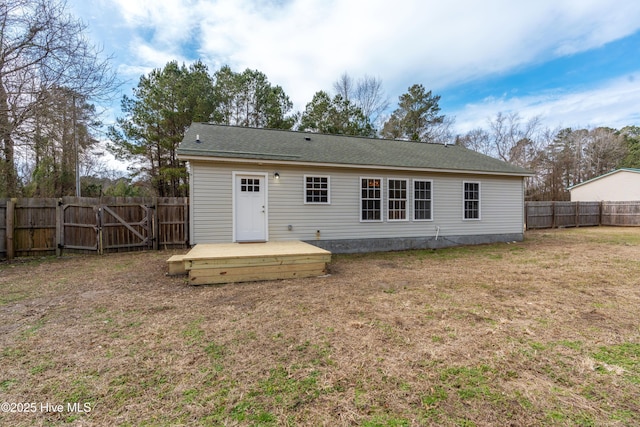 rear view of house with a lawn and a deck