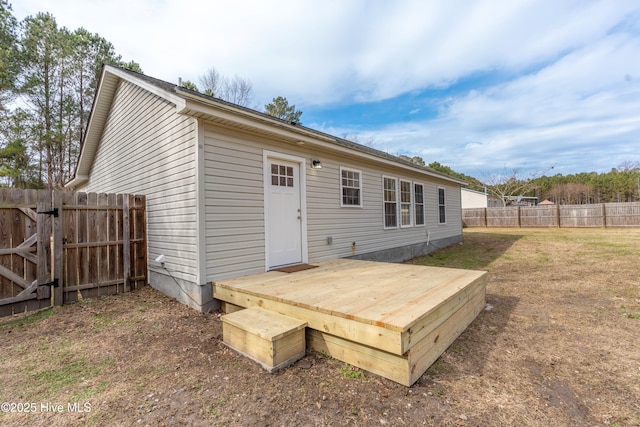 back of house with a deck and a yard