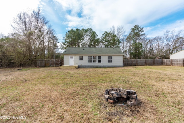 rear view of house featuring an outdoor fire pit and a lawn