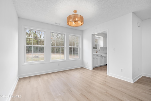 interior space featuring a textured ceiling and light wood-type flooring