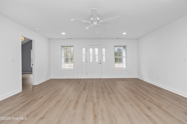 empty room with light hardwood / wood-style floors, ceiling fan, and plenty of natural light