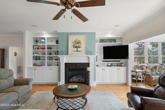 living room with light wood-type flooring, ceiling fan, and crown molding