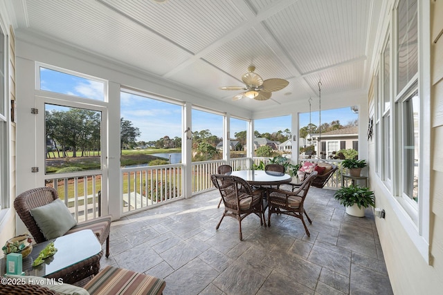 sunroom / solarium with a water view, a healthy amount of sunlight, ceiling fan, and coffered ceiling