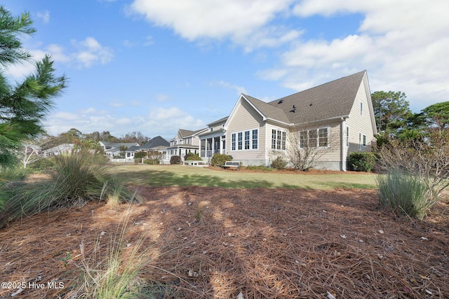 view of side of home with a yard