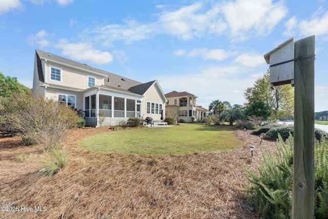 back of property featuring a yard and a sunroom