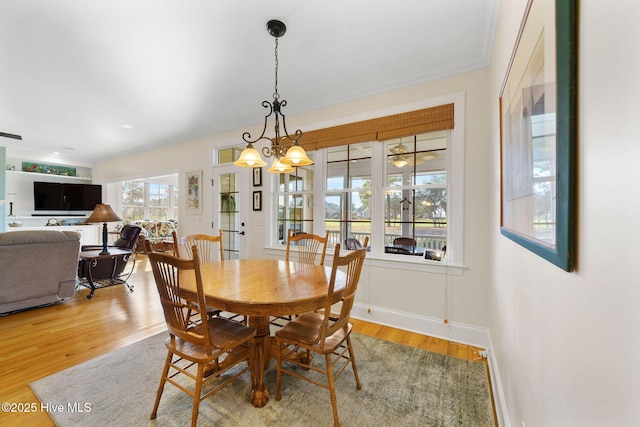 dining room featuring hardwood / wood-style floors, crown molding, and an inviting chandelier