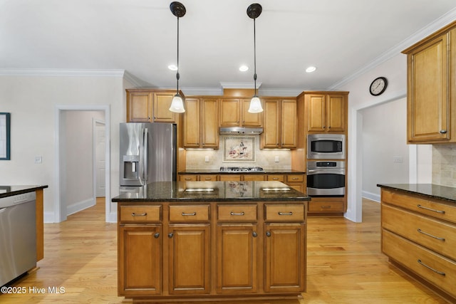 kitchen featuring a center island, pendant lighting, decorative backsplash, stainless steel appliances, and dark stone counters