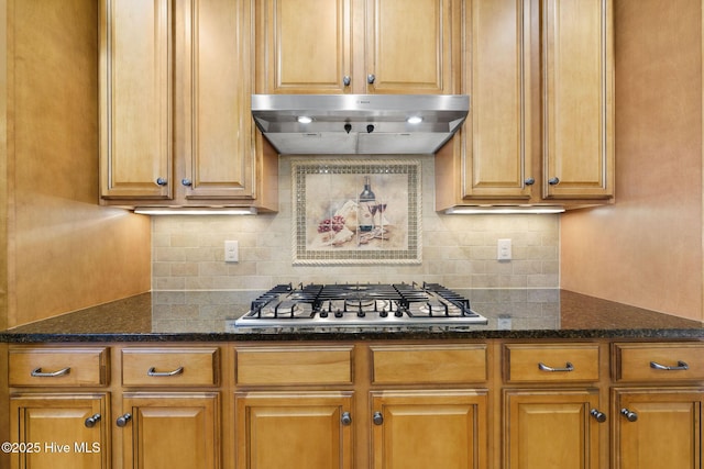 kitchen with tasteful backsplash, stainless steel gas cooktop, and dark stone counters