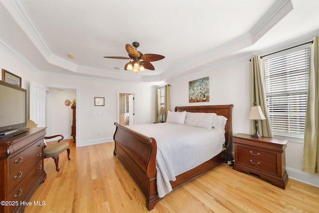 bedroom with ceiling fan, crown molding, light hardwood / wood-style flooring, and a raised ceiling