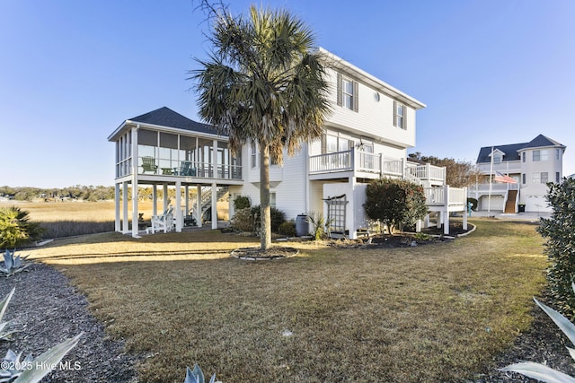 rear view of property with a yard and a sunroom