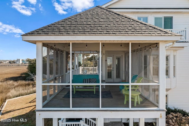 rear view of property with a sunroom and french doors