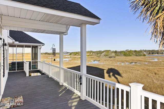 wooden terrace featuring a water view and a sunroom