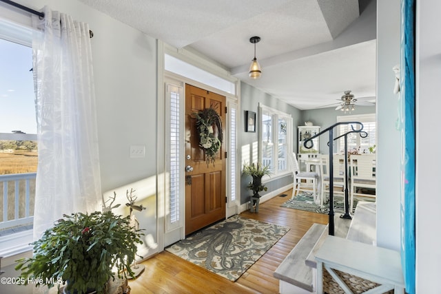 entrance foyer with ceiling fan, wood-type flooring, and a textured ceiling