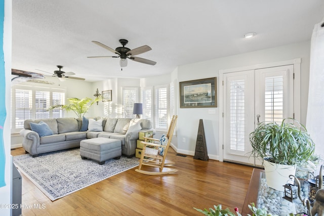 living room featuring ceiling fan, hardwood / wood-style floors, and plenty of natural light