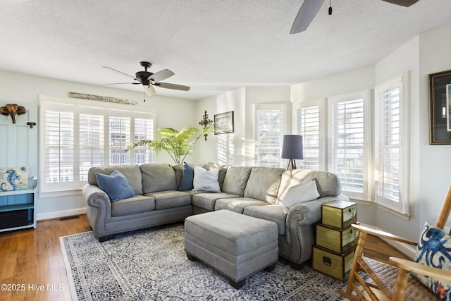 living room with ceiling fan, wood-type flooring, and a textured ceiling