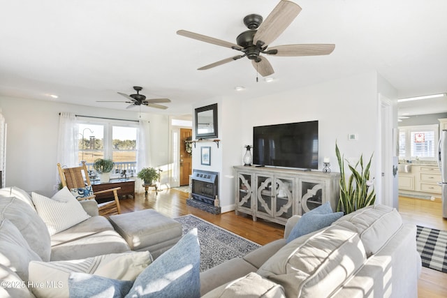 living room with ceiling fan, a fireplace, and hardwood / wood-style floors