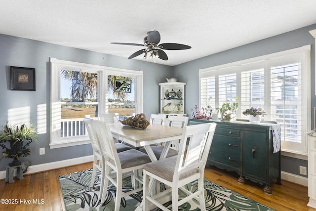 dining room with ceiling fan, dark hardwood / wood-style flooring, and a textured ceiling