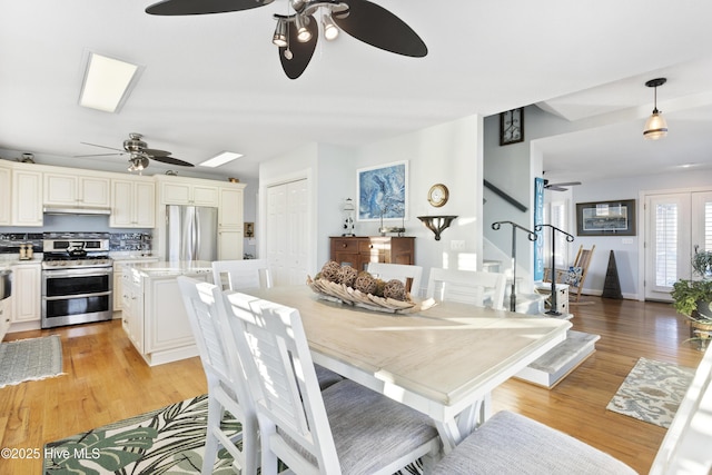 dining space with ceiling fan and light hardwood / wood-style floors