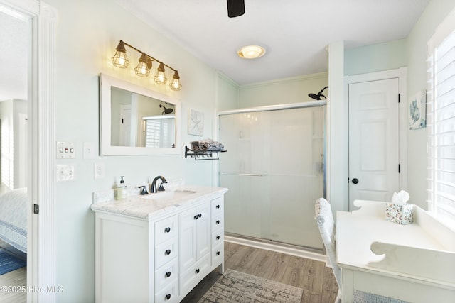 bathroom featuring a shower with shower door, wood-type flooring, and vanity