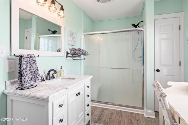 bathroom featuring walk in shower, vanity, and hardwood / wood-style floors