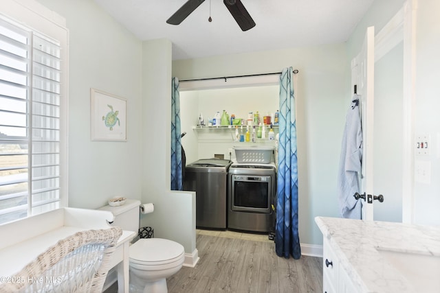 bathroom featuring toilet, hardwood / wood-style floors, washing machine and clothes dryer, ceiling fan, and vanity