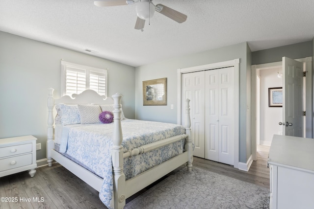 bedroom featuring a textured ceiling, ceiling fan, a closet, and dark wood-type flooring