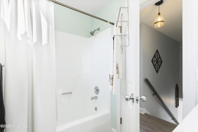 bathroom with hardwood / wood-style flooring and shower / tub combo with curtain