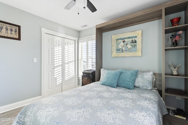 bedroom featuring ceiling fan, dark wood-type flooring, and a closet