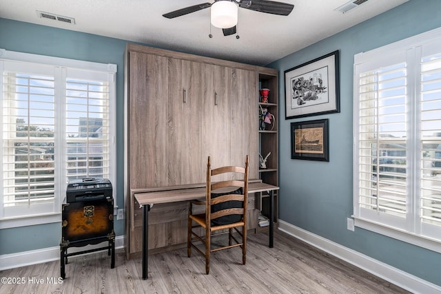 office featuring a textured ceiling, ceiling fan, hardwood / wood-style floors, and plenty of natural light