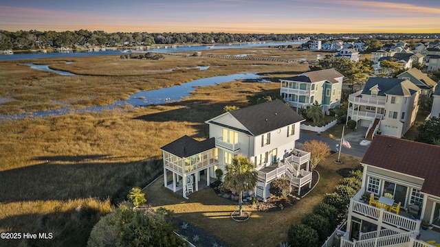 aerial view at dusk featuring a water view