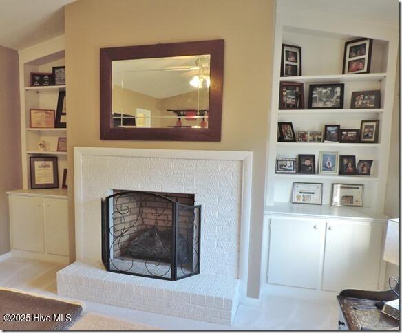 details featuring a brick fireplace and built in features