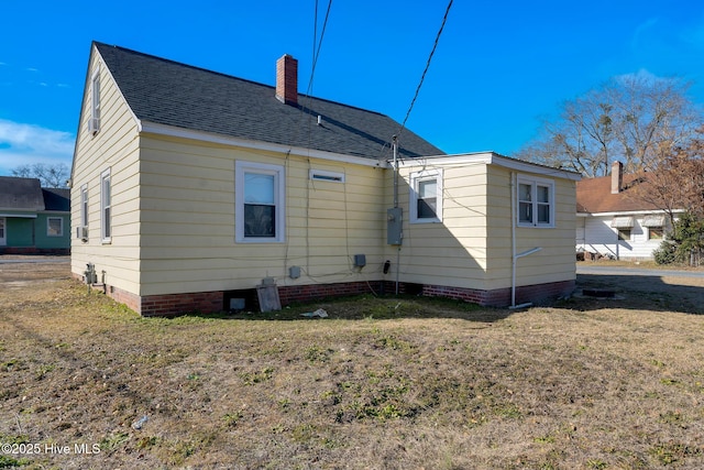 back of property featuring a lawn