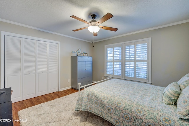 bedroom with hardwood / wood-style floors, crown molding, a closet, and a textured ceiling