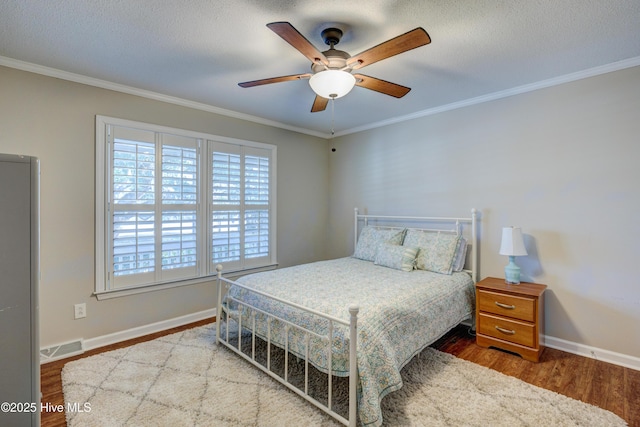 bedroom featuring hardwood / wood-style flooring, crown molding, and a textured ceiling