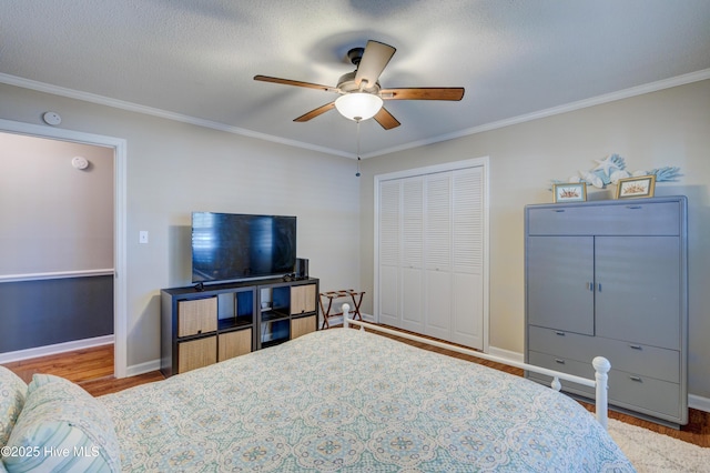 bedroom featuring crown molding, hardwood / wood-style floors, ceiling fan, and a closet