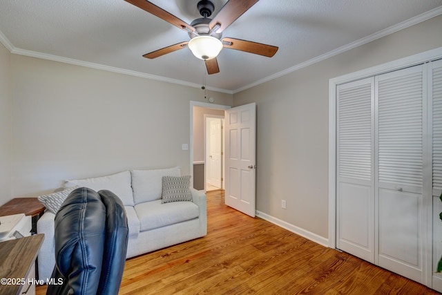 sitting room featuring ornamental molding, ceiling fan, and light wood-type flooring