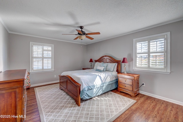 bedroom featuring ornamental molding, ceiling fan, a textured ceiling, and light hardwood / wood-style floors