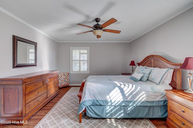 bedroom with dark wood-type flooring, ceiling fan, crown molding, and a textured ceiling