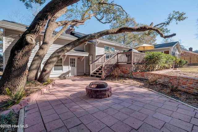 rear view of house featuring an outdoor fire pit, a deck, and a patio area