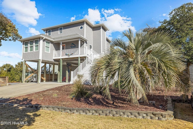 back of house with covered porch and a carport