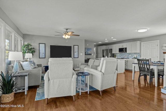 living room featuring ceiling fan and hardwood / wood-style floors