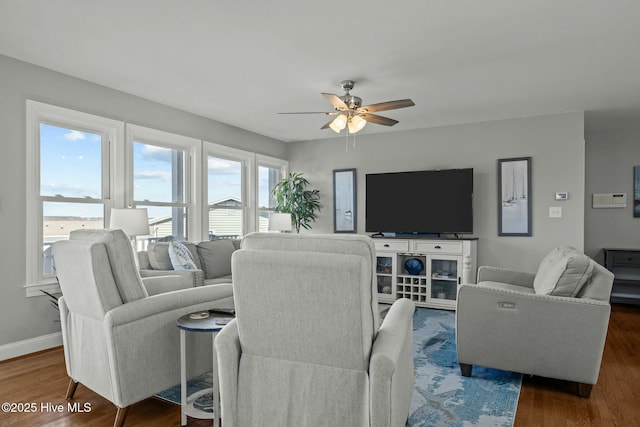 living room with ceiling fan and dark wood-type flooring