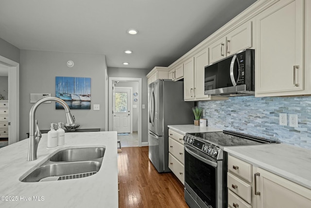 kitchen featuring tasteful backsplash, stainless steel electric range oven, dark hardwood / wood-style flooring, and sink