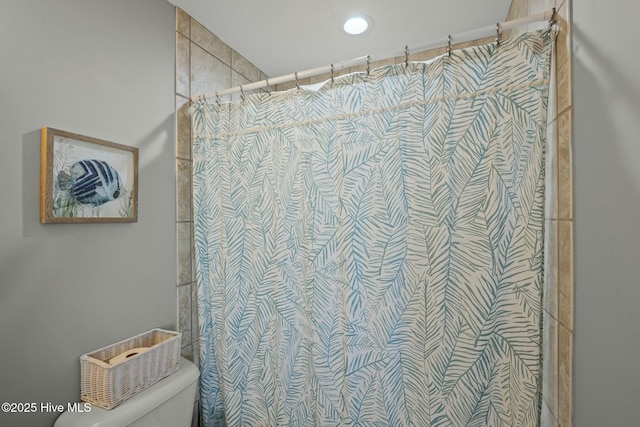 bathroom with curtained shower and toilet